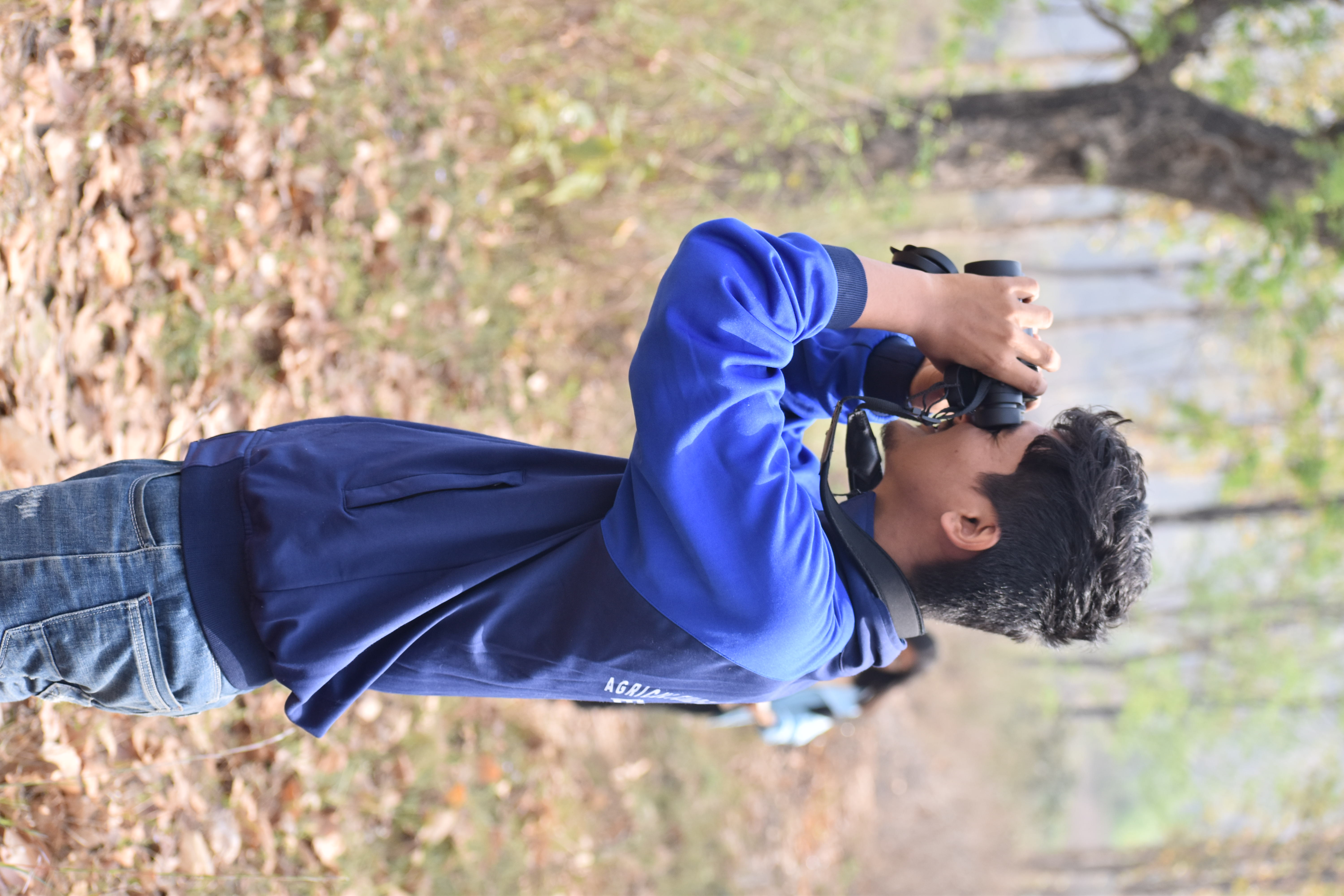 Prashant Chalise in the field with binoculars